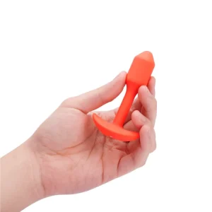 b-Vibe Vibrating Snug Plug S Orange product image A hand holding the b-Vibe Vibrating Snug Plug 1 to demonstrate its beginner-friendly scale and size.