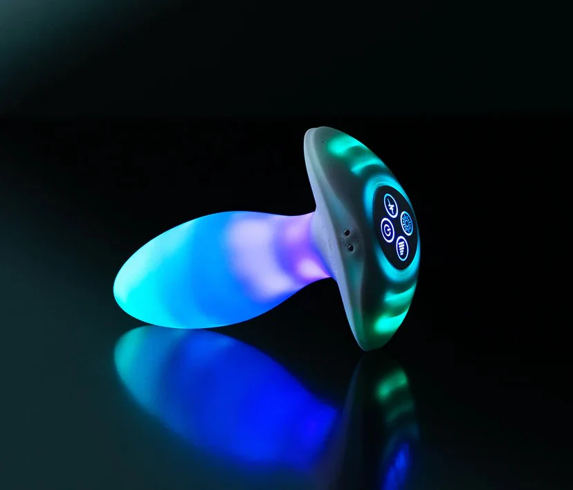 Illumination THE Plug App Controlled LED Butt Plug product image Trendsetting illuminated butt plug glowing with vivid custom RGB colors sitting on an angle against a black background