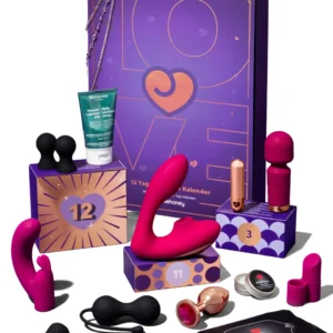 A complete collection of all 12 items from the Amorana Indulge Advent Calendar 2026 arranged in front of the purple box. Includes pink vibrators, black anal toys, lube, wipes, and balm against a white background.